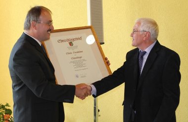 Bild: Edwin Gensheimer erhält die Urkunde zum Ehrenbürger von Ortsbürgermeister Harald Jentzer.