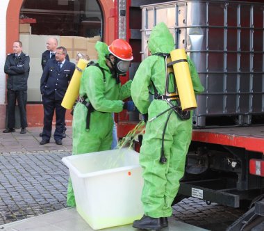 Bild: Mit speziell angefertigten Chemikalienschutzanzügen demonstriert die Jugendfeuerwehr einen Gefahrstoffeinsatz.