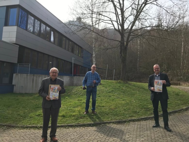 "Mit dem Geschäftsführer des Trifelsvereins, Walter Schmitt, bei der Übergabe der Bücher an die Förderschule an Herrn Daibel - mit dem Trifels im Hintergrund. Was ein schöner Arbeitsplatz, an dem man den Trifels immer im Blick hat." (Marcus Ehrgott)